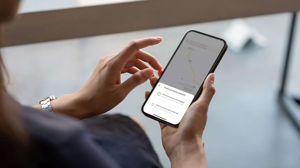 Primo piano mani di donna che utilizza app per parcheggio ParkingMyCar su smartphone