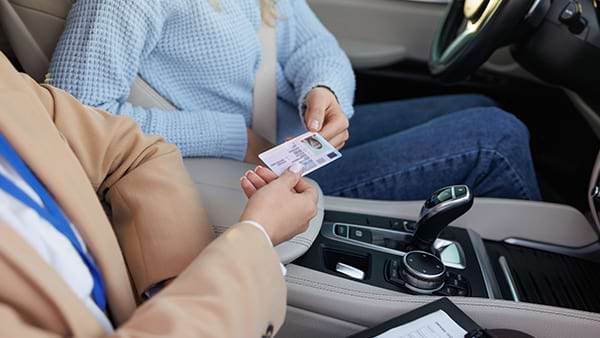 Ragazza riceve la patente di guida al termine dell'esame pratico